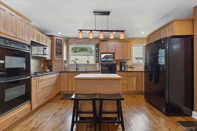 1101 Shallowdale Dr, Troy, MI 48085 - kitchen featuring black appliances, light wood-style floors, decorative backsplash, a kitchen island, and glass insert cabinets