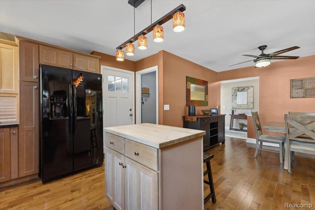 1101 Shallowdale Dr, Troy, MI 48085 - kitchen with black refrigerator with ice dispenser, ceiling fan, light wood-type flooring, and a kitchen bar