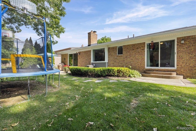 1101 Shallowdale Dr, Troy, MI 48085 - rear view of property featuring a trampoline, entry steps, brick siding, and a yard