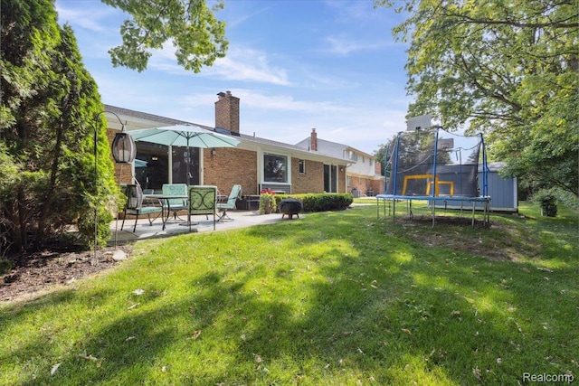 1101 Shallowdale Dr, Troy, MI 48085 - back of property with a trampoline, a patio area, brick siding, a lawn, and a chimney