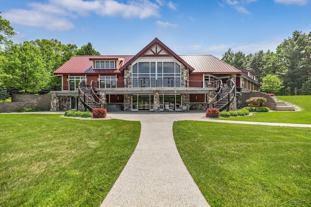 199 E Brooks Rd, Midland, MI 48640 - back of house featuring stairs, stone siding, a metal roof, a lawn, and a carport