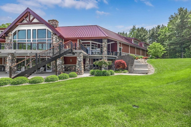 199 E Brooks Rd, Midland, MI 48640 - view of front of house with stairway, stone siding, a chimney, a front yard, and a metal roof