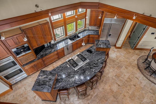 199 E Brooks Rd, Midland, MI 48640 - kitchen with stainless steel appliances, brown cabinetry, stone finish floors, and tasteful backsplash