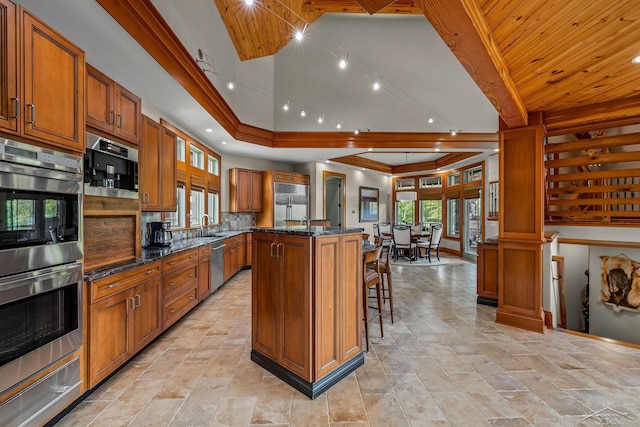 199 E Brooks Rd, Midland, MI 48640 - kitchen featuring stainless steel appliances, a kitchen island, brown cabinetry, a warming drawer, and a kitchen breakfast bar