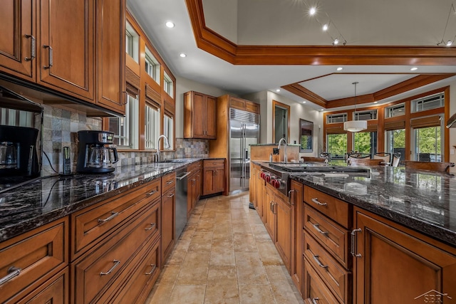 199 E Brooks Rd, Midland, MI 48640 - kitchen featuring stainless steel appliances, a tray ceiling, brown cabinetry, decorative backsplash, and dark stone counters