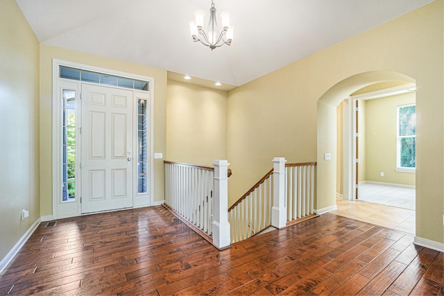 8842 Oakland Hills Cir, Portage, MI 49024 - foyer with hardwood / wood-style floors, arched walkways, a chandelier, and vaulted ceiling
