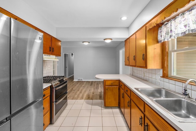 3050 Sharon Ave SW, Wyoming, MI 49519 - kitchen with stainless steel appliances, under cabinet range hood, decorative backsplash, light countertops, and recessed lighting