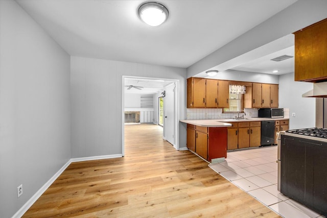 3050 Sharon Ave SW, Wyoming, MI 49519 - kitchen featuring stainless steel microwave, black dishwasher, gas range oven, light countertops, and light wood-style floors