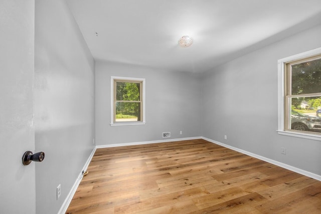 3050 Sharon Ave SW, Wyoming, MI 49519 - empty room with healthy amount of natural light and light wood finished floors