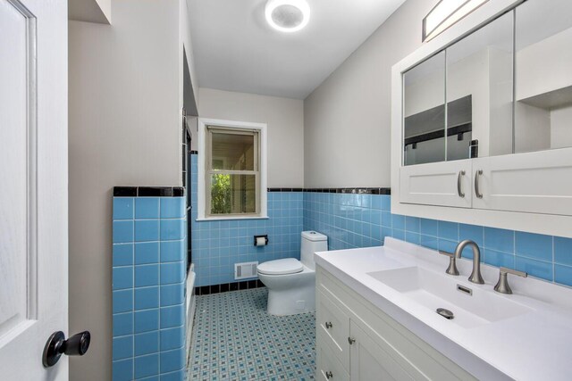 3050 Sharon Ave SW, Wyoming, MI 49519 - full bathroom featuring tile walls, wainscoting, vanity, washtub / shower combination, and tile patterned floors