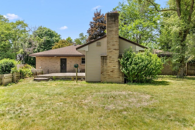 3050 Sharon Ave SW, Wyoming, MI 49519 - rear view of house featuring a chimney, brick siding, and a deck
