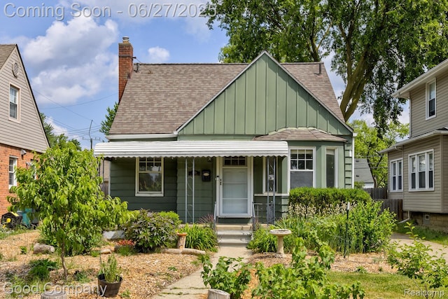 830 W Hazelhurst St, Ferndale, MI 48220 - view of front of property featuring board and batten siding, a shingled roof, a porch, and a chimney