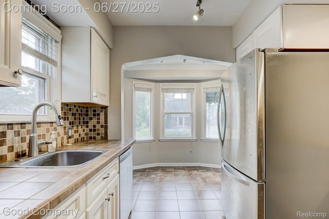 830 W Hazelhurst St, Ferndale, MI 48220 - kitchen with appliances with stainless steel finishes, tile counters, white cabinets, and decorative backsplash