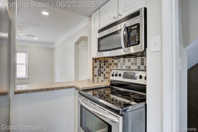830 W Hazelhurst St, Ferndale, MI 48220 - kitchen featuring appliances with stainless steel finishes, white cabinetry, decorative backsplash, and recessed lighting