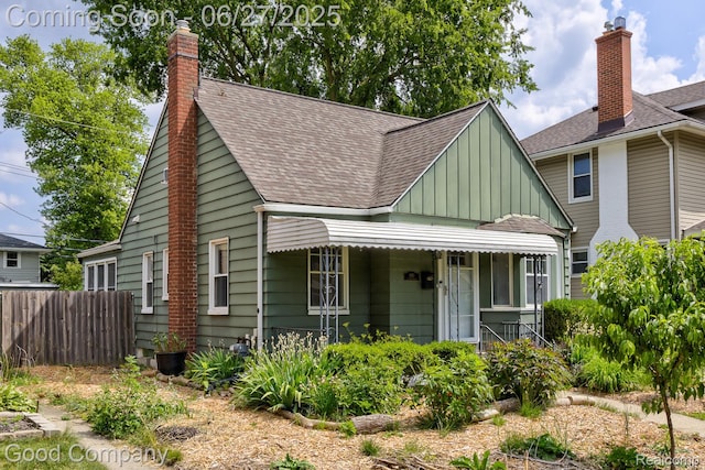 830 W Hazelhurst St, Ferndale, MI 48220 - view of front of house featuring board and batten siding, roof with shingles, covered porch, and a chimney
