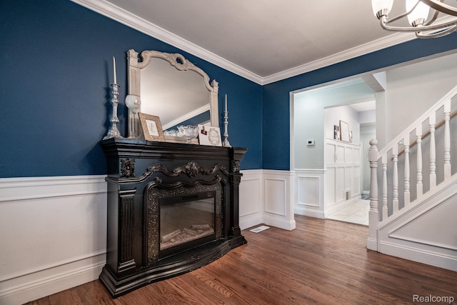 625 Whitcomb Ave, Royal Oak, MI 48073 - living room with a chandelier, a wainscoted wall, a glass covered fireplace, wood finished floors, and stairway