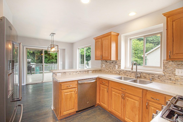 11275 Grand Oaks Dr, Clio, MI 48420 - kitchen featuring appliances with stainless steel finishes, light countertops, a peninsula, dark wood finished floors, and decorative backsplash