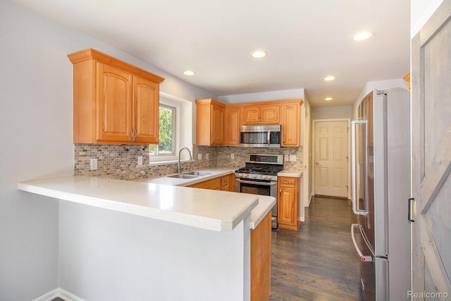 11275 Grand Oaks Dr, Clio, MI 48420 - kitchen featuring stainless steel appliances, a peninsula, dark wood-style flooring, tasteful backsplash, and light countertops