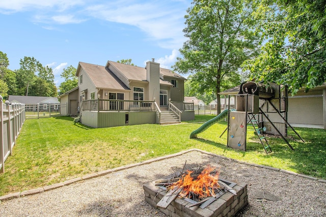 11275 Grand Oaks Dr, Clio, MI 48420 - back of property with a playground, a fire pit, a fenced backyard, and a wooden deck