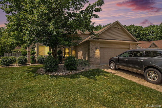 11275 Grand Oaks Dr, Clio, MI 48420 - view of front of property with an attached garage, brick siding, a front lawn, and driveway