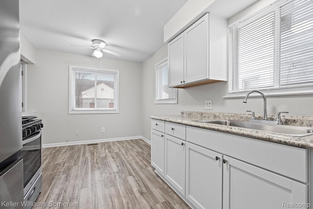 7568 Dodge Ave, Warren, MI 48091 - kitchen featuring appliances with stainless steel finishes, a ceiling fan, light wood-type flooring, and white cabinetry