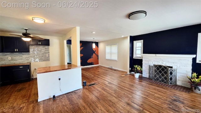 12280 Wade St, Detroit, MI 48213 - kitchen featuring wood counters, a stone fireplace, dark wood-style floors, decorative backsplash, and recessed lighting