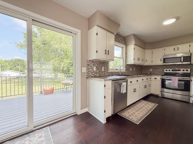 56570 Warren Dr, Dowagiac, MI 49047 - kitchen featuring appliances with stainless steel finishes, tasteful backsplash, dark wood-style flooring, and white cabinetry
