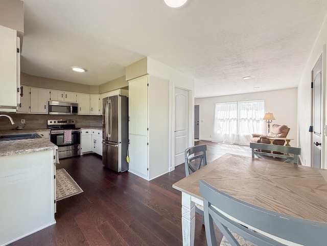 56570 Warren Dr, Dowagiac, MI 49047 - kitchen featuring appliances with stainless steel finishes, dark wood-type flooring, light countertops, recessed lighting, and tasteful backsplash