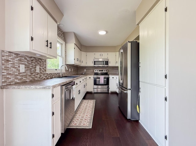 56570 Warren Dr, Dowagiac, MI 49047 - kitchen featuring appliances with stainless steel finishes, dark wood-style floors, light countertops, decorative backsplash, and white cabinets