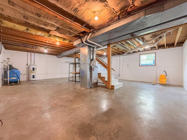 56570 Warren Dr, Dowagiac, MI 49047 - below grade area featuring water heater, stairway, a water pressure tank, and heating unit