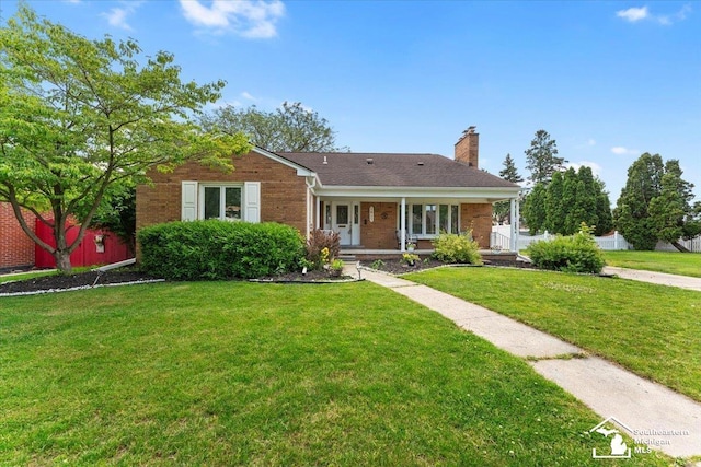 1617 Davis St, Wyandotte, MI 48192 - ranch-style house with a front yard, a chimney, brick siding, and covered porch