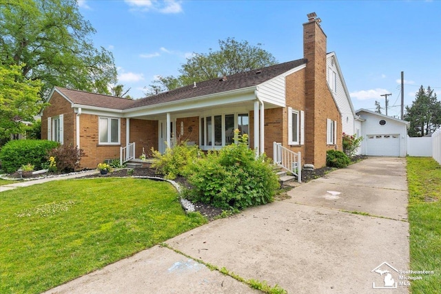 1617 Davis St, Wyandotte, MI 48192 - view of front of home featuring brick siding, a garage, a front lawn, a chimney, and an outbuilding