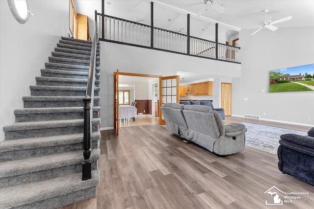 1617 Davis St, Wyandotte, MI 48192 - living room with stairs, a towering ceiling, ceiling fan, wood finished floors, and a fireplace