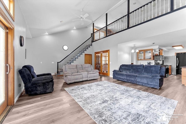 1617 Davis St, Wyandotte, MI 48192 - living area with high vaulted ceiling, stairway, healthy amount of natural light, ceiling fan, and light wood-style floors