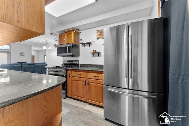 1617 Davis St, Wyandotte, MI 48192 - kitchen featuring stainless steel appliances, light wood-type flooring, open shelves, brown cabinetry, and dark stone countertops