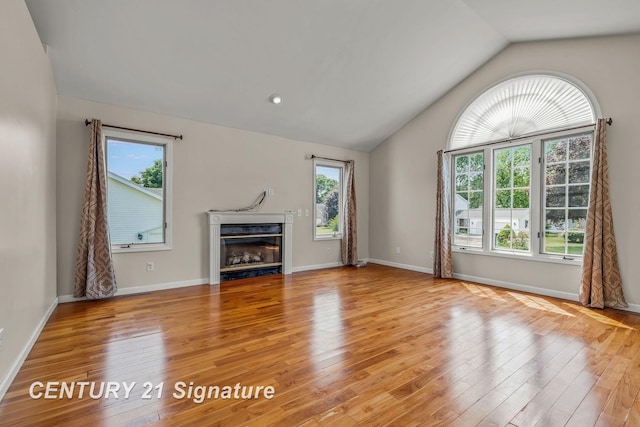2364 Milford Dr, Saginaw, MI 48603 - unfurnished living room featuring lofted ceiling, light wood finished floors, and a glass covered fireplace