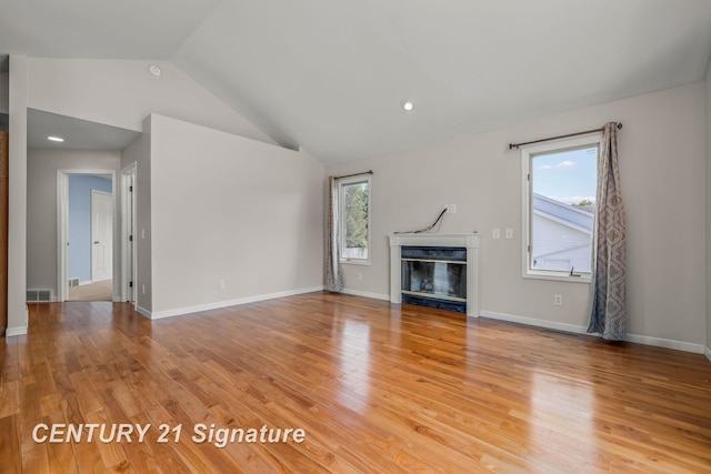2364 Milford Dr, Saginaw, MI 48603 - unfurnished living room featuring lofted ceiling, a glass covered fireplace, and light wood-type flooring