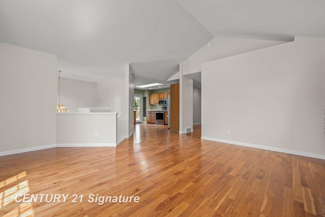 2364 Milford Dr, Saginaw, MI 48603 - unfurnished living room featuring light wood finished floors, a chandelier, and vaulted ceiling