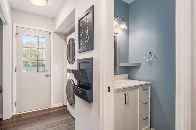 2104 Waterbury Dr SE, Kentwood, MI 49508 - washroom with stacked washing machine and dryer and dark wood-style flooring