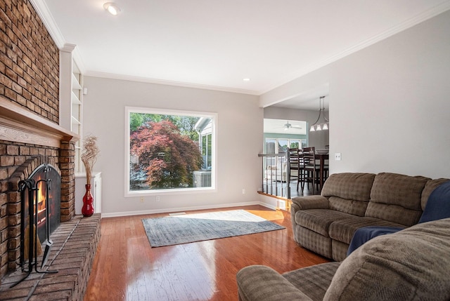 2104 Waterbury Dr SE, Kentwood, MI 49508 - living room featuring healthy amount of natural light, crown molding, wood finished floors, a brick fireplace, and recessed lighting