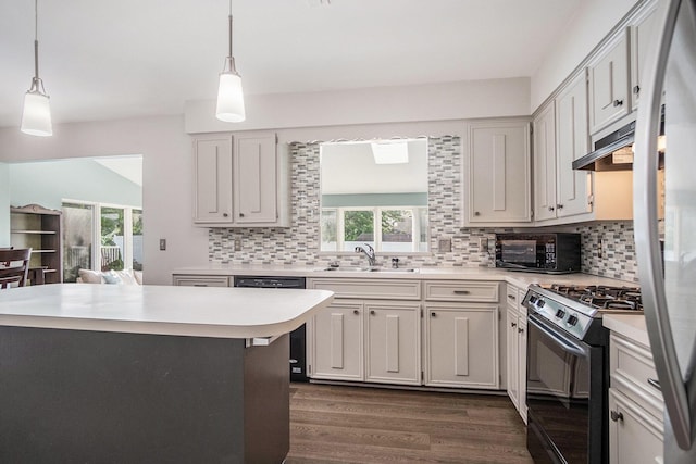 2104 Waterbury Dr SE, Kentwood, MI 49508 - kitchen with black appliances, under cabinet range hood, light countertops, dark wood-style floors, and healthy amount of natural light