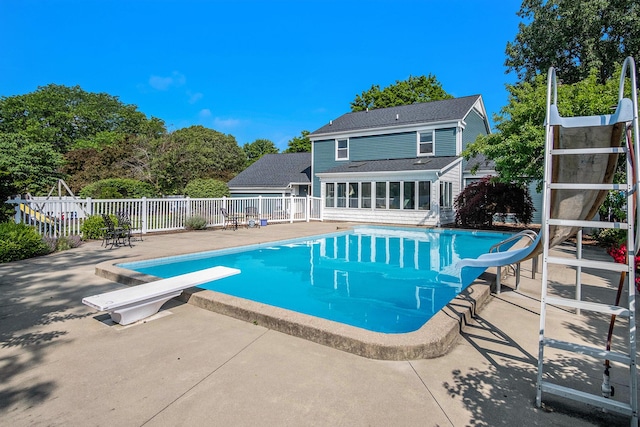 2104 Waterbury Dr SE, Kentwood, MI 49508 - view of pool with a water slide, a sunroom, a diving board, and a patio