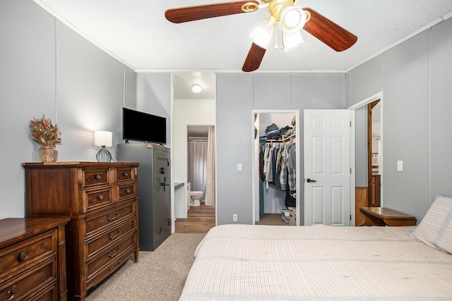 12467 S Running Deer Ln, Grant, MI 49327 - bedroom featuring light colored carpet, a walk in closet, a closet, connected bathroom, and ornamental molding