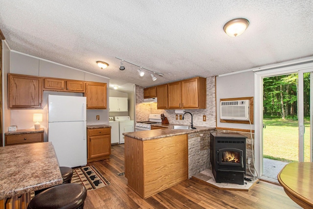 12467 S Running Deer Ln, Grant, MI 49327 - kitchen with white appliances, washing machine and dryer, a textured ceiling, dark wood-style flooring, and tasteful backsplash