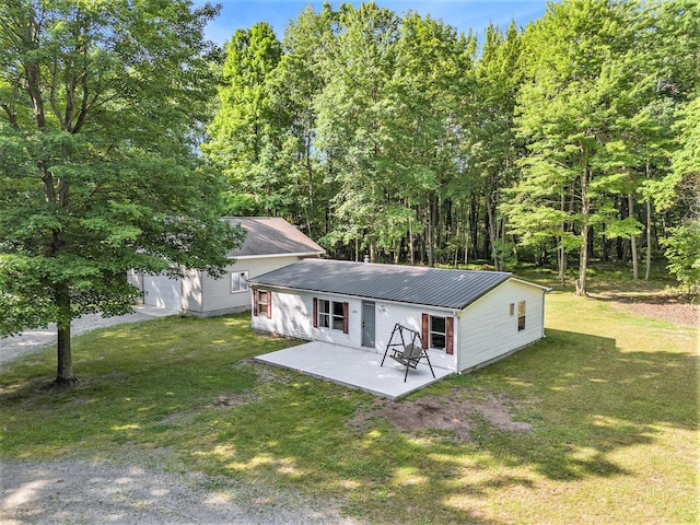 12467 S Running Deer Ln, Grant, MI 49327 - back of property with a patio area, a lawn, and a metal roof