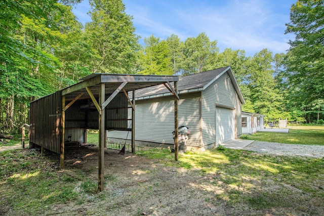 12467 S Running Deer Ln, Grant, MI 49327 - view of side of property with an outbuilding, a detached garage, driveway, and a yard