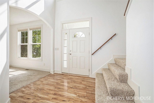7511 Emerald Woods SE, Byron Center, MI 49315 - foyer with arched walkways, plenty of natural light, light wood-style flooring, and stairs