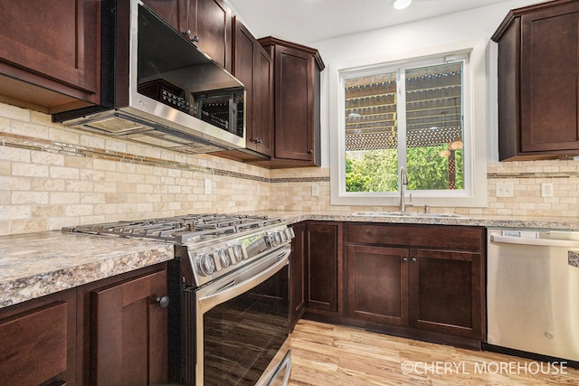 7511 Emerald Woods SE, Byron Center, MI 49315 - kitchen with appliances with stainless steel finishes, dark brown cabinets, decorative backsplash, recessed lighting, and light wood finished floors