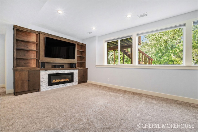 7511 Emerald Woods SE, Byron Center, MI 49315 - unfurnished living room with a glass covered fireplace, carpet floors, and recessed lighting