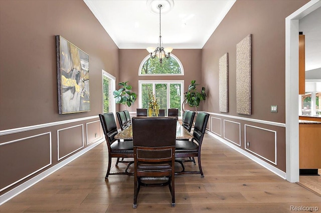6280 Branford Dr, West Bloomfield, MI 48322 - dining area with a decorative wall, a chandelier, wood finished floors, wainscoting, and ornamental molding